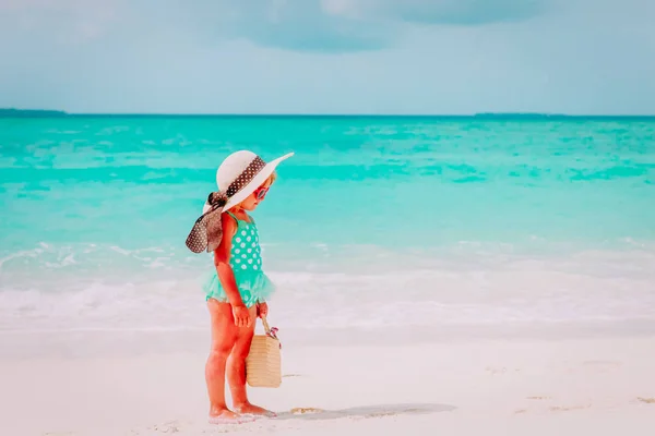 Linda niña con bolsa de playa y sombrero en el mar —  Fotos de Stock