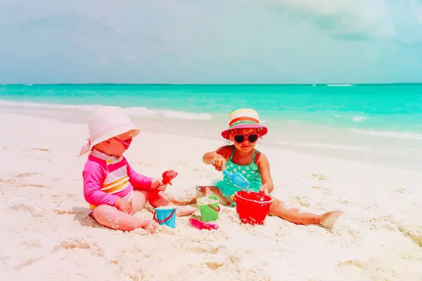 Meninas brincam com areia na praia — Fotografia de Stock