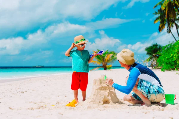 Padre e figlio costruzione castello sulla spiaggia di sabbia — Foto Stock