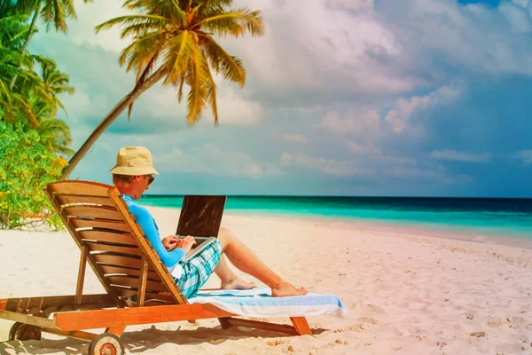 Man met laptop op tropisch strand — Stockfoto