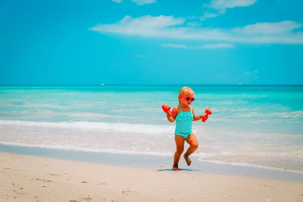 Niedliche kleine Mädchen spielen mit Sand am Strand — Stockfoto