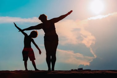 Günbatımı gökyüzü aile oynayan silüeti