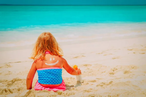 Solskydd på stranden - lilla flicka tillämpa sunblock grädde på axel — Stockfoto