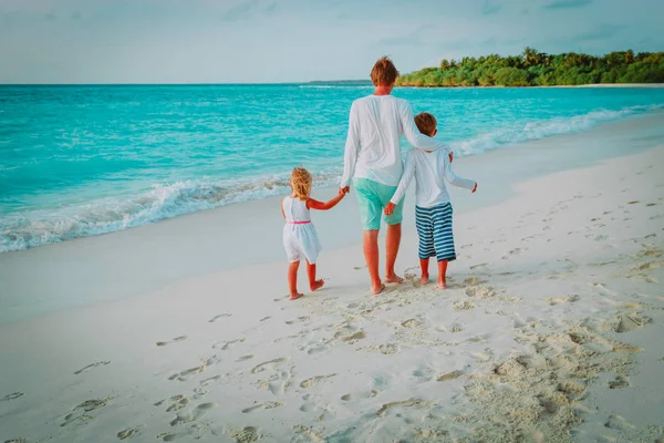 Padre e due bambini a piedi sulla spiaggia — Foto Stock
