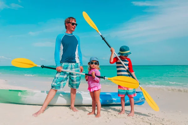 Отец с маленьким сыном и дочь на каяке на пляже — стоковое фото