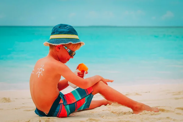 Protezione solare- bambino con crema solare in spiaggia — Foto Stock