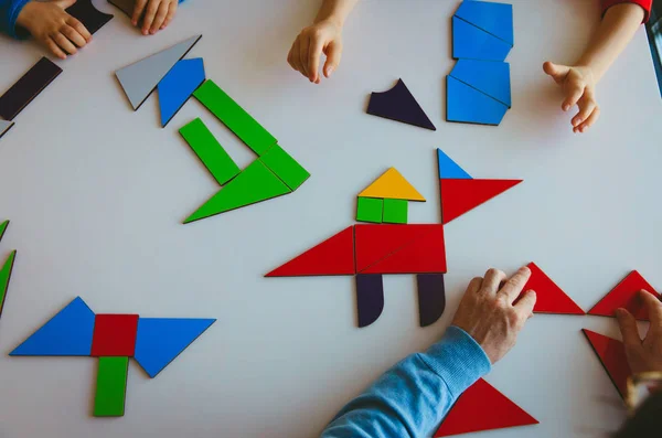 Tanár és a gyerekek játszani, puzzle vagy tangram, oktatás — Stock Fotó