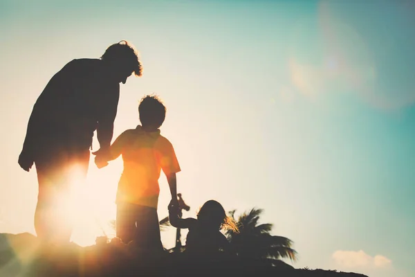 Silhueta de família com crianças brincam na praia do pôr do sol — Fotografia de Stock