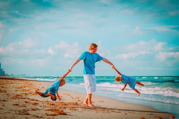 Padre con hijo e hija juegan en la playa — Foto de Stock