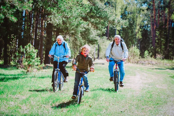 Petit garçon avec des grands-parents à vélo dans la nature — Photo