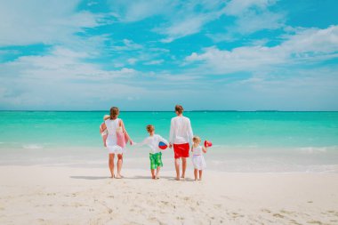 mutlu aile çocuklarla sahilde yürümek