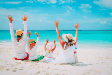 İki çocuklu mutlu aile kumsalda eller