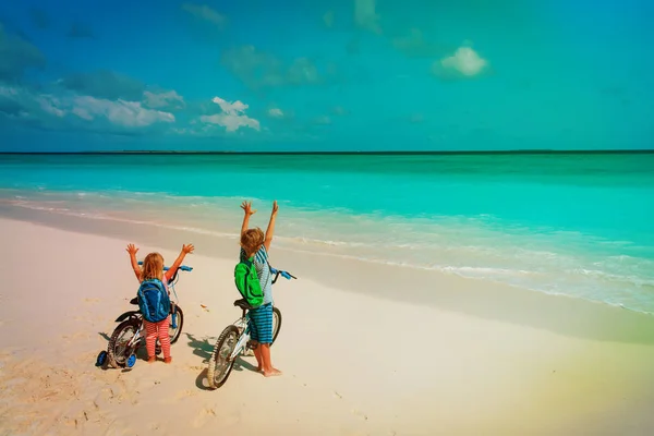 Niño y niña montar en bicicleta en la playa —  Fotos de Stock