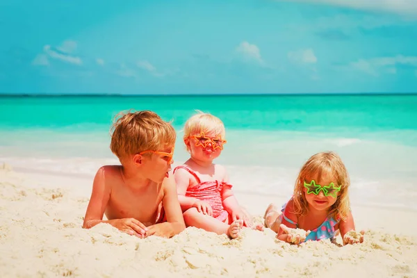 Kids -little boy and girls- play with sand on beach — Stock Photo, Image