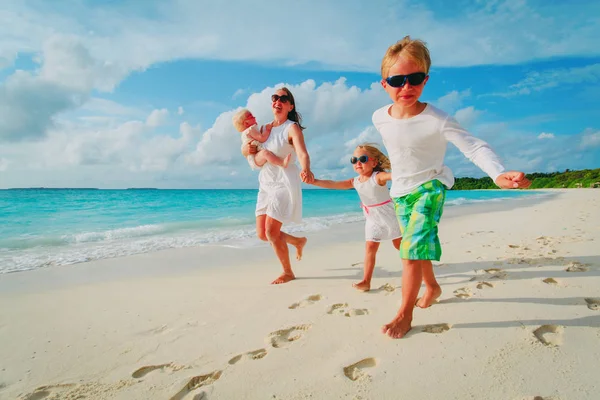 Matka s dětmi hrát na tropické pláži — Stock fotografie