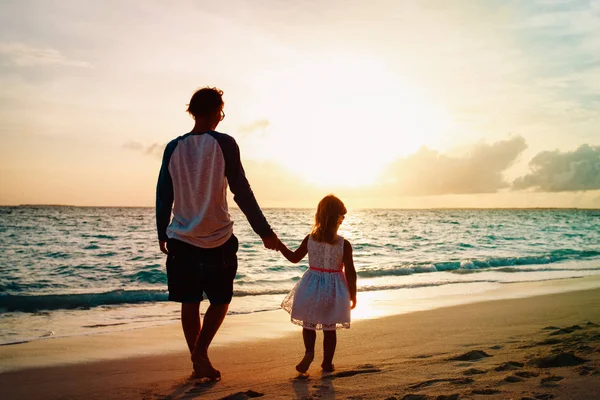 Pai e filha andando na praia ao pôr do sol — Fotografia de Stock