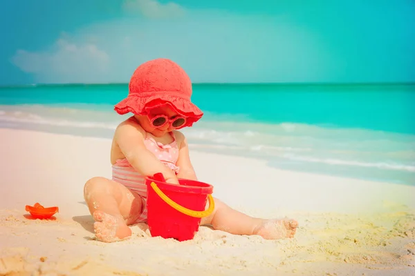 Cute little girl play with sand on beach — Stock Photo, Image