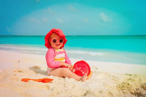 Cute little girl grać z piasku na plaży — Zdjęcie stockowe