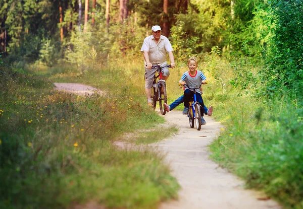 Senior actif avec ses petits-enfants en vélo dans la nature — Photo