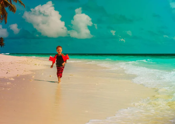 Mały chłopiec run gra z wody na tropikalnej plaży — Zdjęcie stockowe