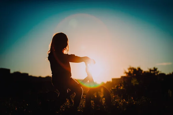Liten flicka ridning cykeln vid solnedgången, aktiva barn — Stockfoto