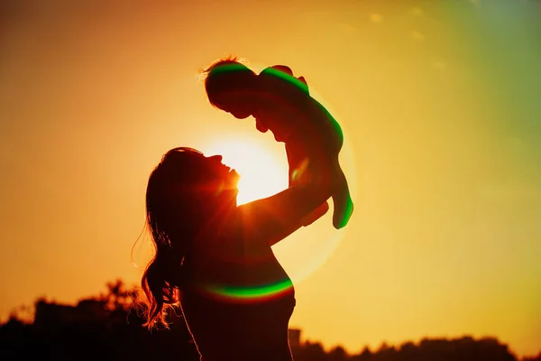 Η μητέρα και το μωράκι παίζουν ηλιοβασίλεμα του ουρανού — Φωτογραφία Αρχείου