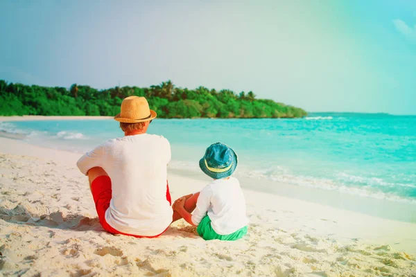 Ojciec i syn niewiele patrząc na morzu na plaży — Zdjęcie stockowe