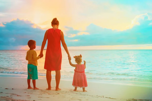 Mutter und zwei Kinder spazieren am Strand — Stockfoto
