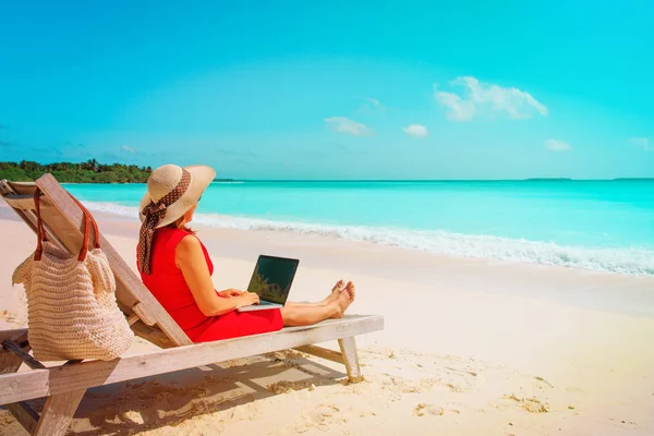 Молода жінка з ноутбуком на тропічному пляжі — стокове фото