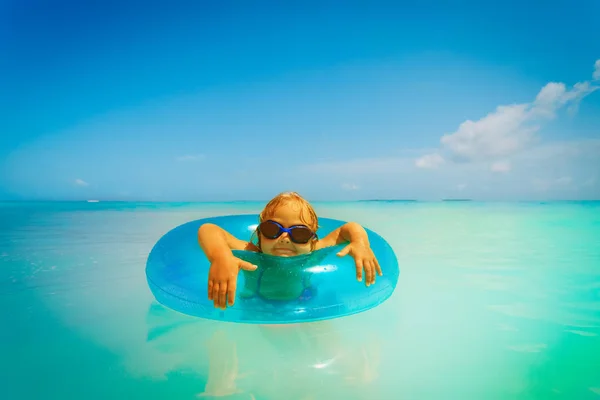 Liten flicka med uppblåsbar ring har kul på tropical beach — Stockfoto