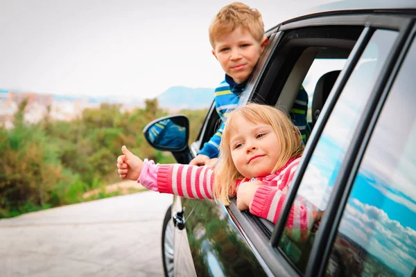Happy kids travel by car on road in nature — Stock Photo, Image