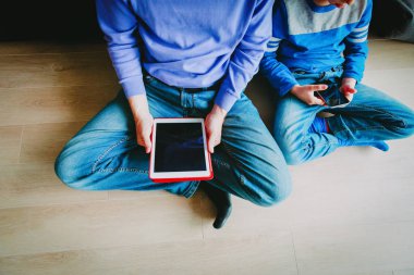 dokunmatik yüzey ve telefon bakarak oğluyla baba