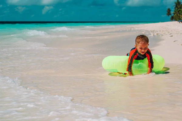 Kleiner Junge mit aufblasbarem Ring hat Spaß am tropischen Strand — Stockfoto