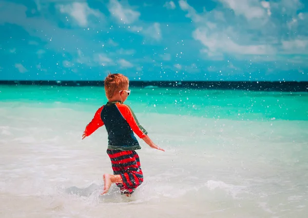 Mały chłopiec run gra z wody na plaży — Zdjęcie stockowe