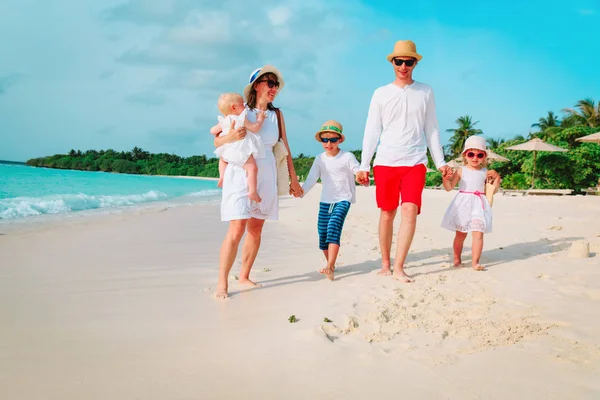 Üç çocuklu mutlu bir aile sahilde yürüyor. — Stok fotoğraf