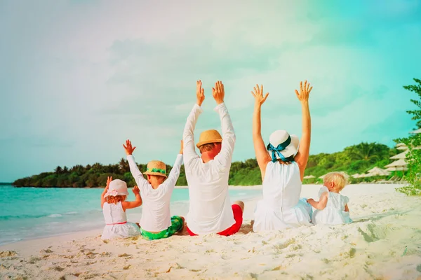 Gelukkige familie met kinderen handen omhoog op strand — Stockfoto