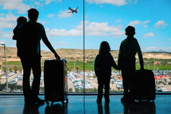 Madre con niños y equipaje mirando aviones en el aeropuerto —  Fotos de Stock