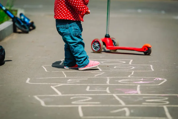 Gadis kecil bermain hopscotch di taman bermain — Stok Foto