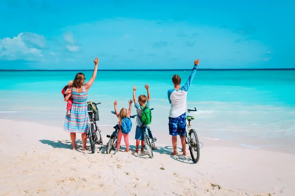 Šťastná rodina s dětmi na kolech na pláži — Stock fotografie