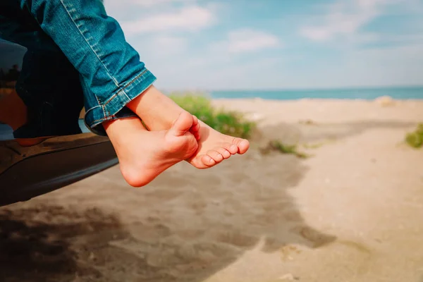 Füße eines kleinen Mädchens fahren mit dem Auto am Strand — Stockfoto