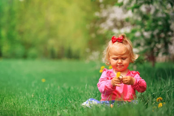 Schattig klein meisje met bloemen in de lente natuur — Stockfoto