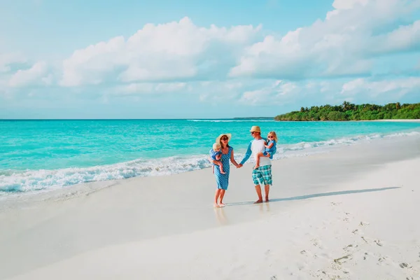 Familia feliz con dos niños caminando en la playa —  Fotos de Stock