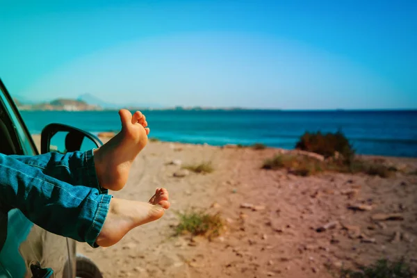 Füße eines kleinen Mädchens fahren mit dem Auto am Strand — Stockfoto