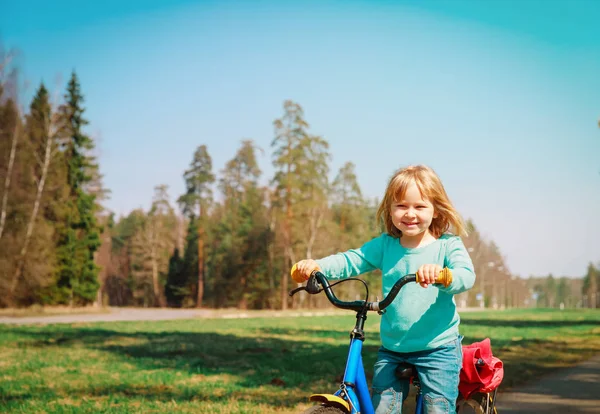 Щаслива маленька дівчинка їде на велосипеді в природі — стокове фото