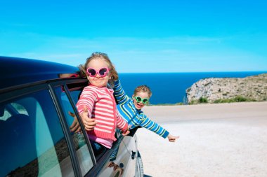 mutlu küçük erkek ve kız denizde arabayla seyahat keyfini çıkarın