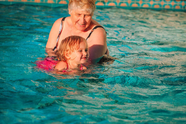 grandmother teaching little granddaughter to swim