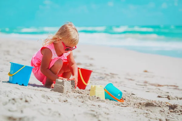 Schattig klein meisje spelen met zand op het strand — Stockfoto