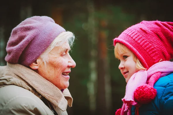Happy grandmother and granddaughter talk in nature — Stock Photo, Image