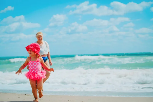 Linda niña feliz con la abuela en la playa — Foto de Stock