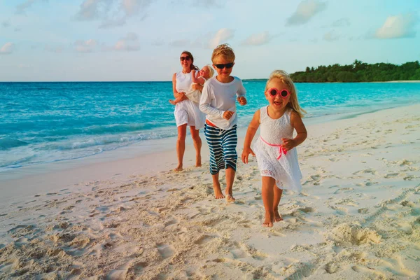 Matka s dětmi hrát na tropické pláži — Stock fotografie